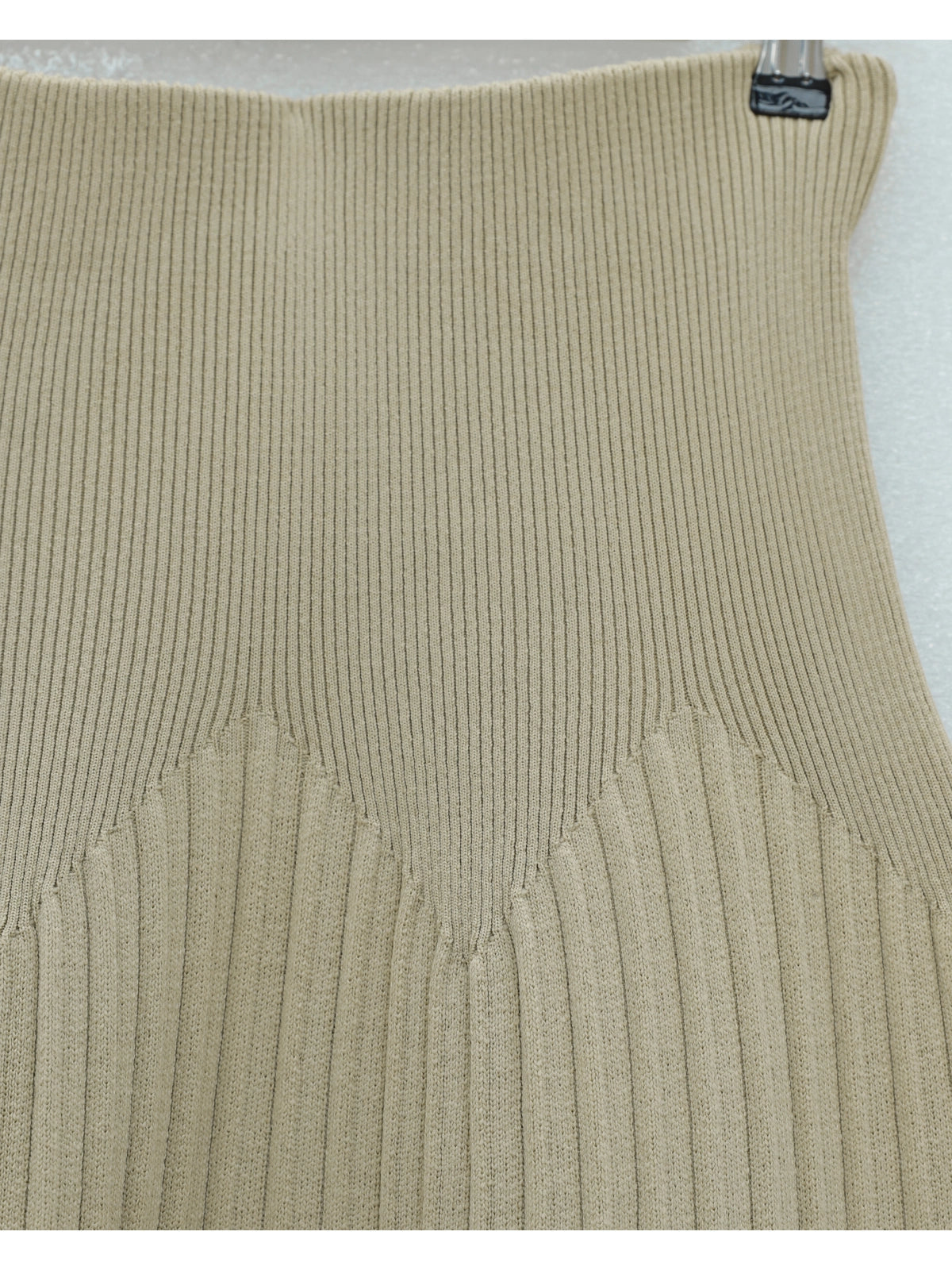 Beige ribbed knit sleeveless top on a light gray background