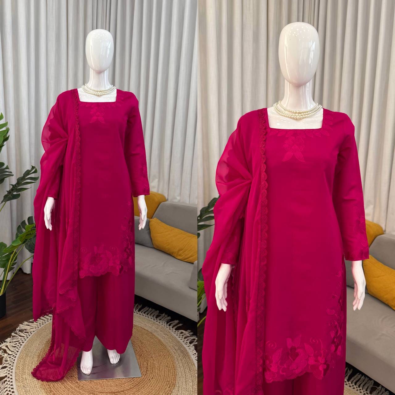 Two mannequins wearing a magenta traditional outfit with a plain background